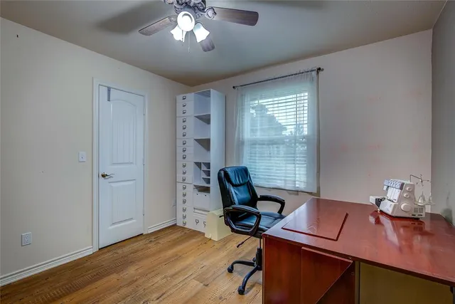 a view of a workspace with furniture and a window