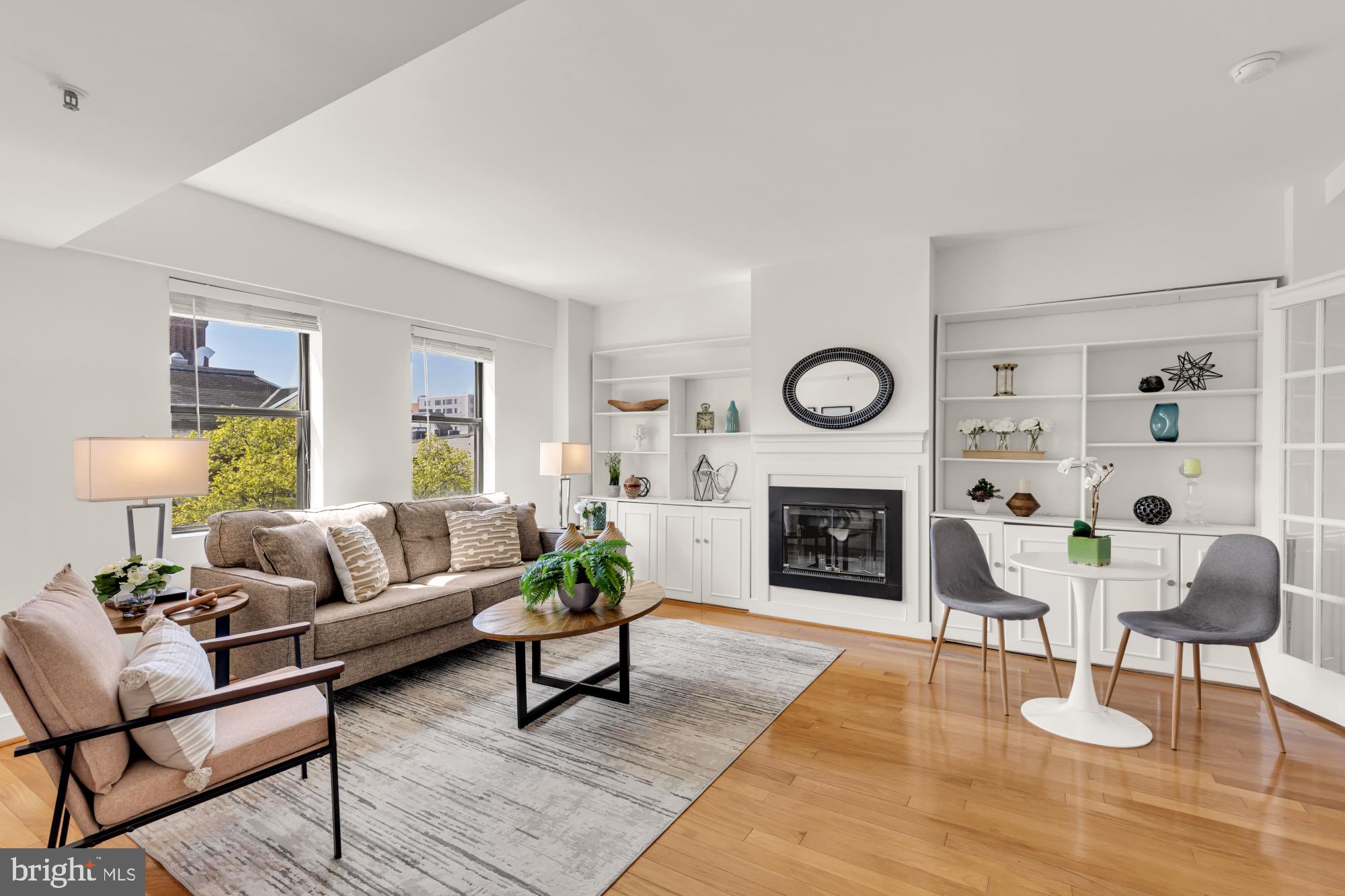a living room with furniture a fireplace a rug and a window