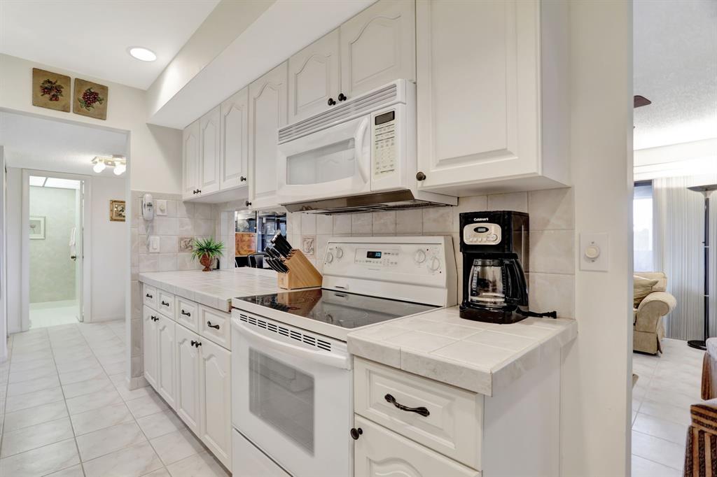 330 Southeast 20th Avenue, Unit 307 Deerfield Beach, FL 33441 - Photo 21 of 48 a kitchen with white cabinets and white appliances