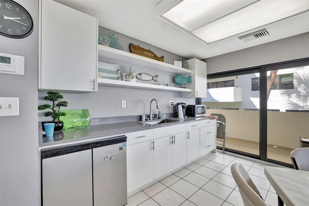 330 Southeast 20th Avenue, Unit 307 Deerfield Beach, FL 33441 - Photo 45 of 48 a kitchen with stainless steel appliances a sink and a refrigerator