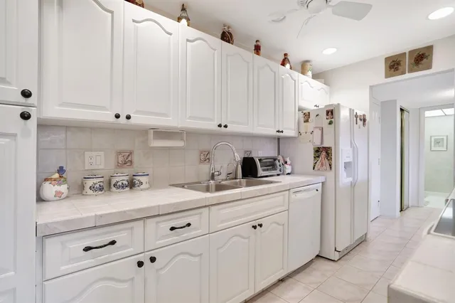 a kitchen with white cabinets and white appliances