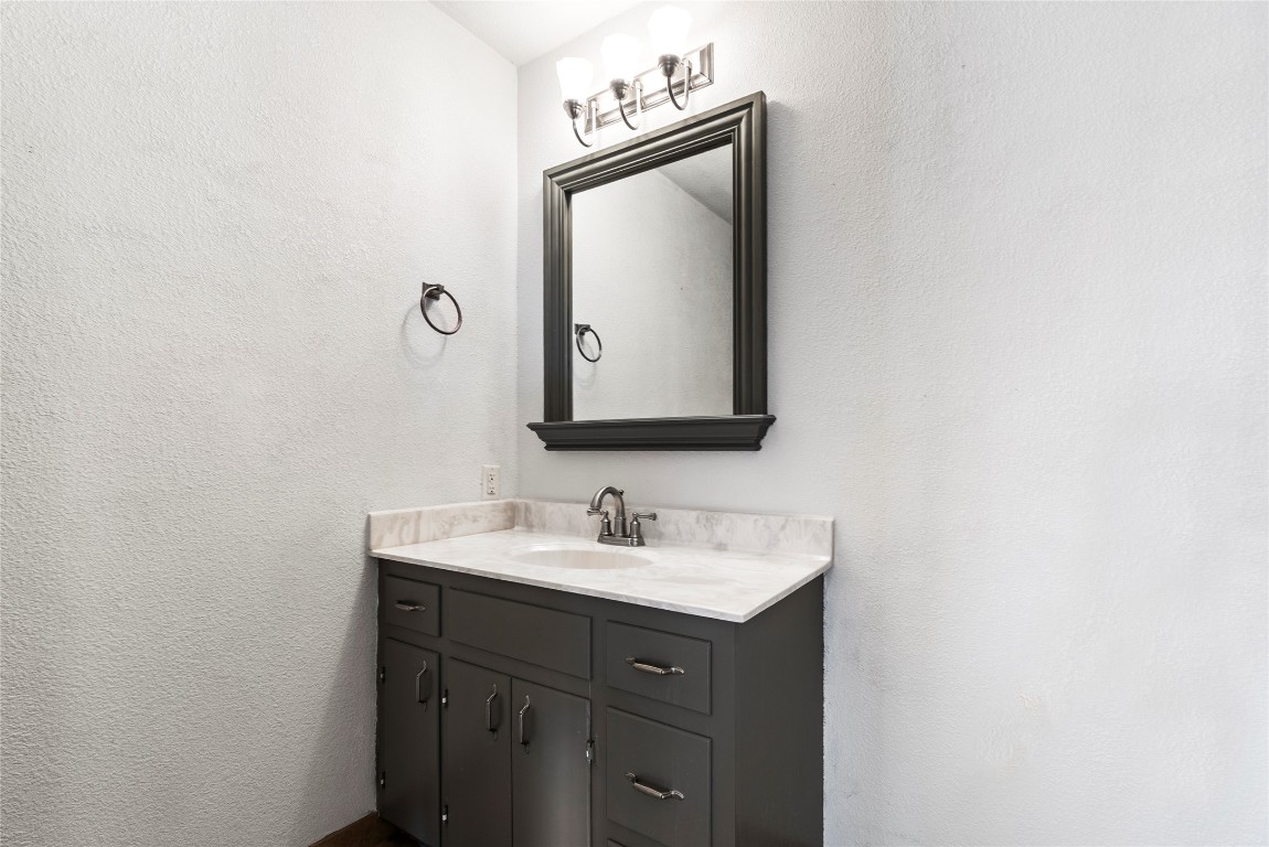 12914 Pfluger Berkman Road Coupland, TX 78615 - Photo 16 of 39 a bathroom with a sink vanity and mirror