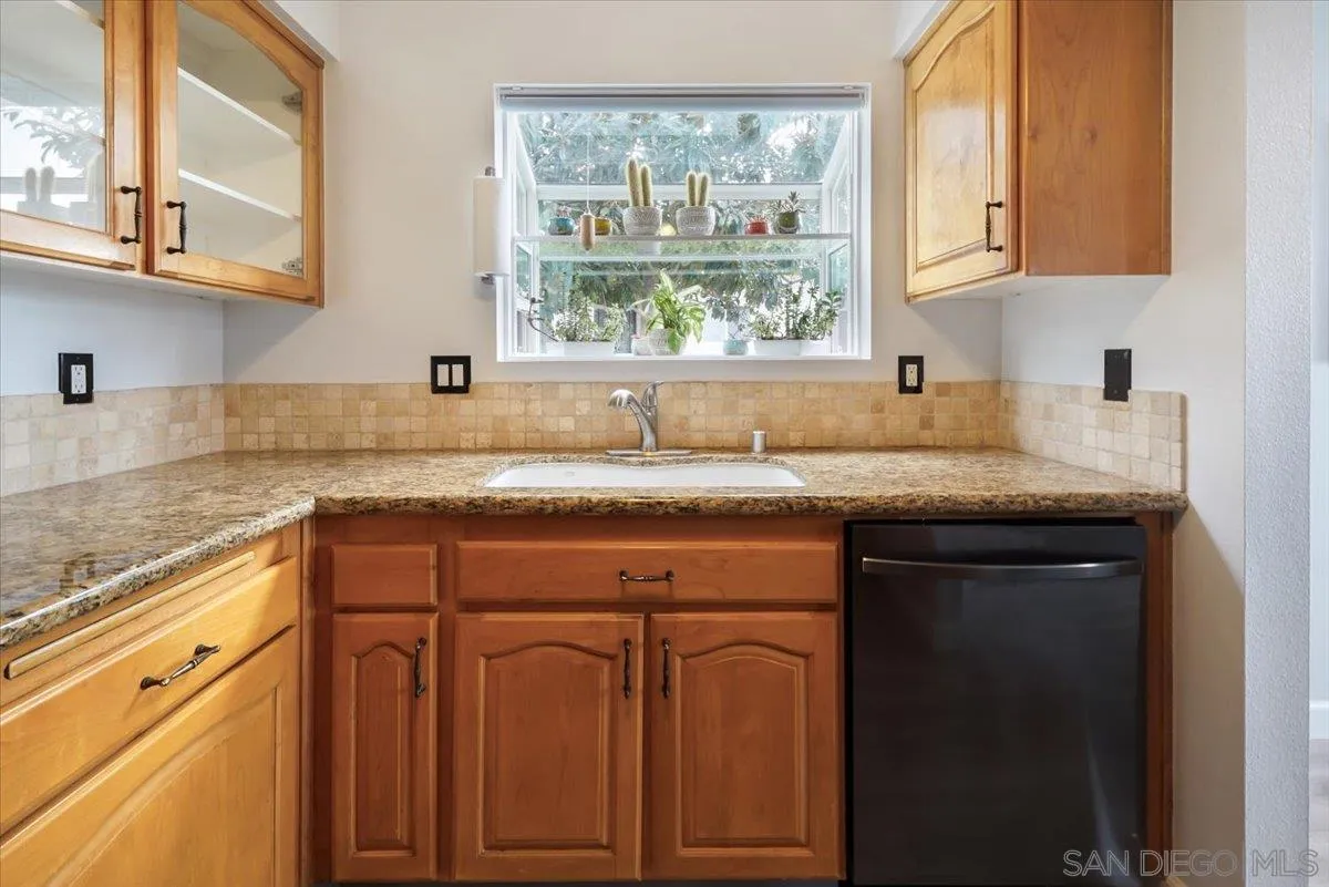 4436 Skimmer Way Oceanside, CA 92057 - Photo 7 of 71 a kitchen with granite countertop a sink window and cabinets