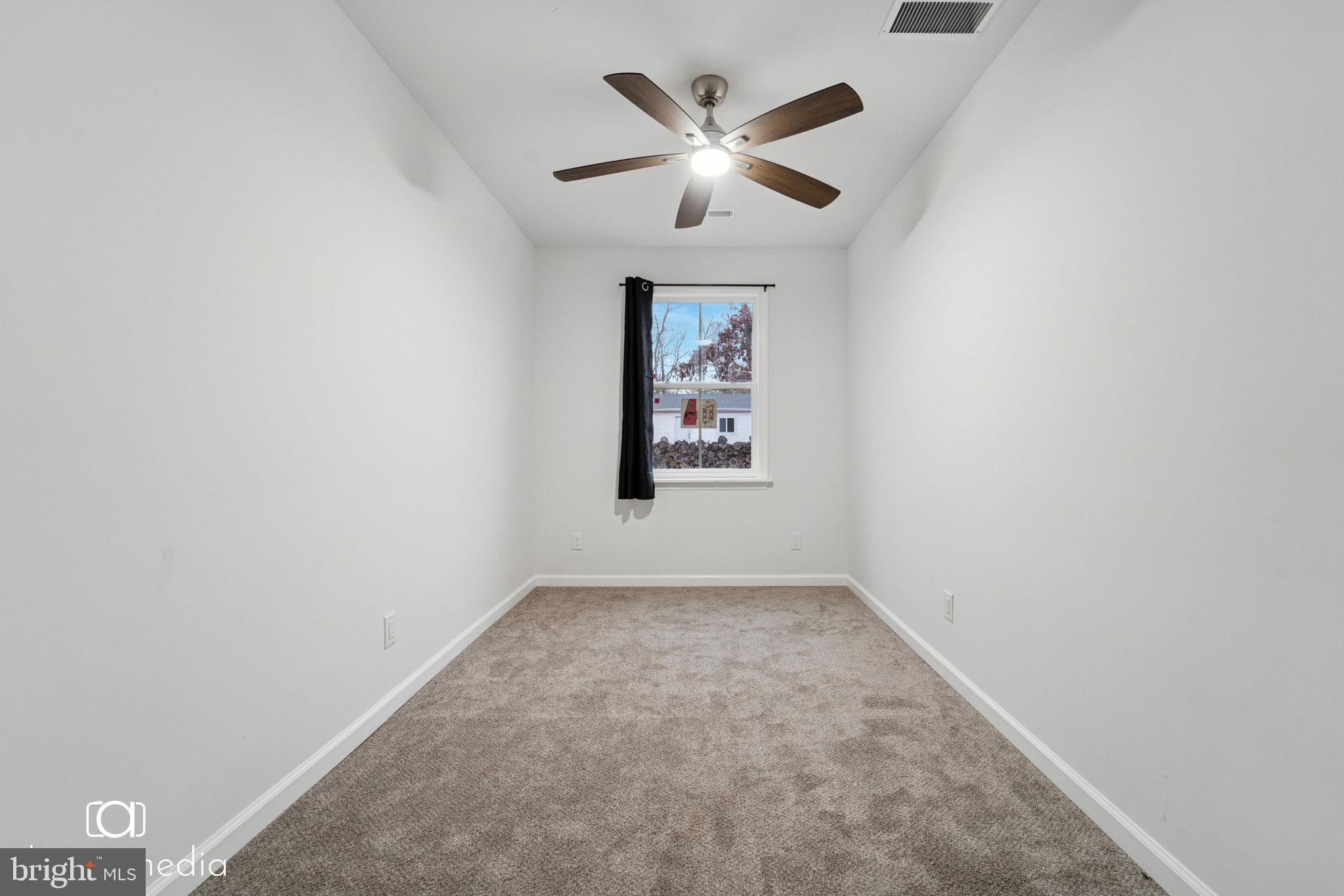 303 Gooseberry Road Millville, NJ 08332 - Photo 13 of 22 an empty room with a window and a fan