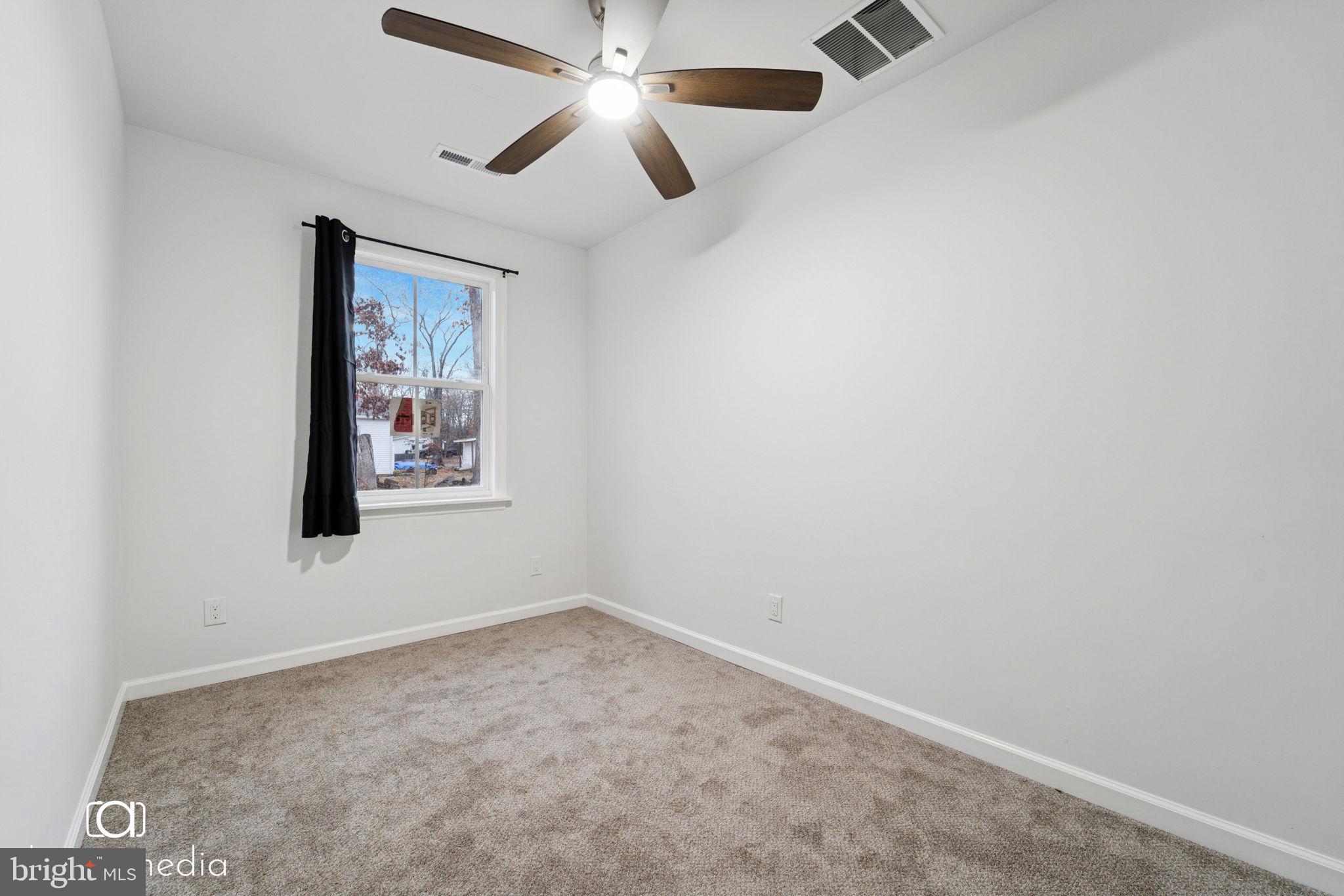 303 Gooseberry Road Millville, NJ 08332 - Photo 14 of 22 an empty room with a window and a fan