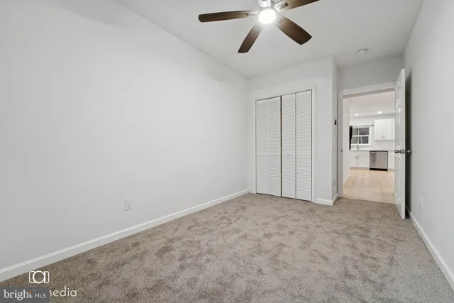 an empty room with closet and windows