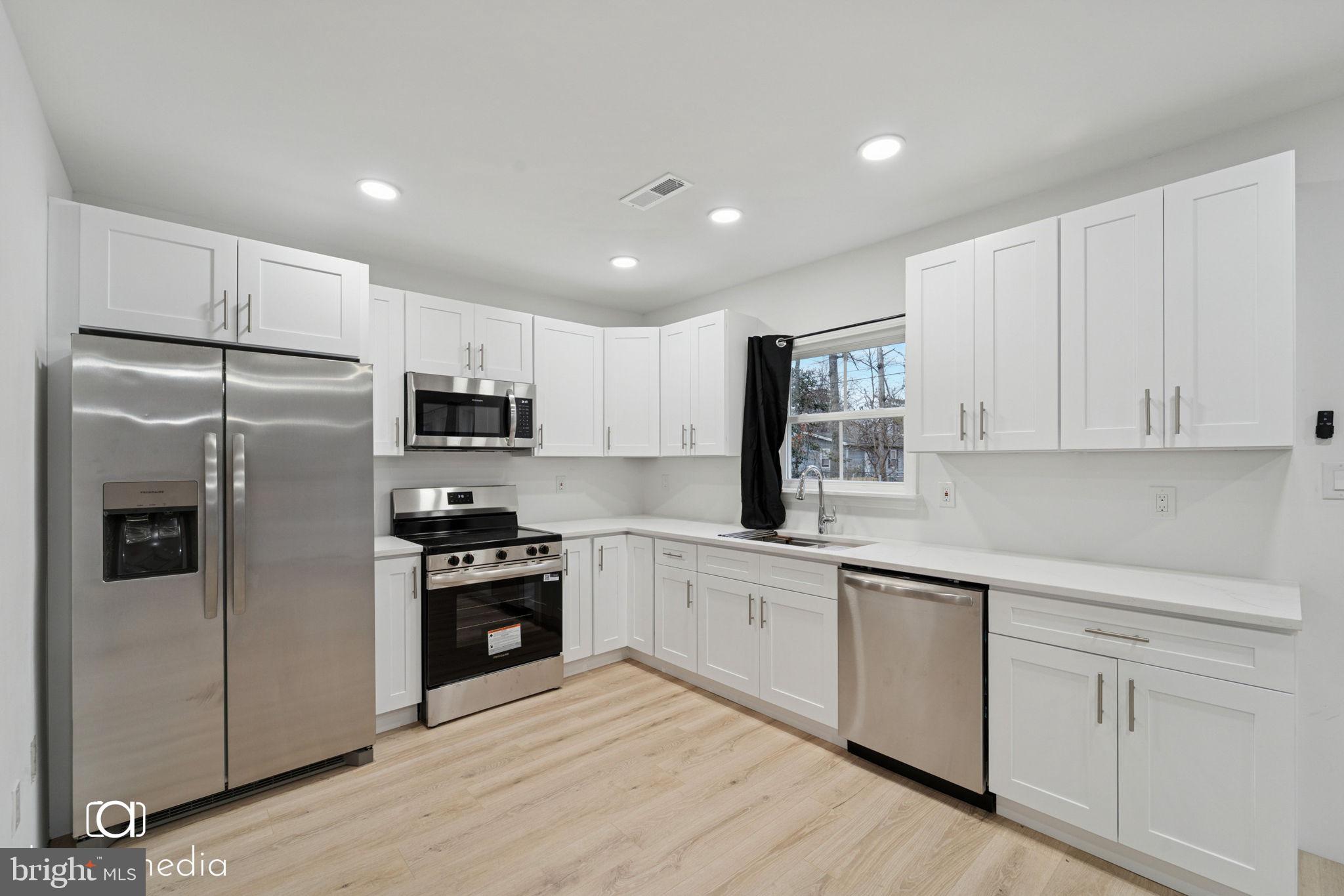 303 Gooseberry Road Millville, NJ 08332 - Photo 5 of 22 a kitchen with white cabinets and stainless steel appliances