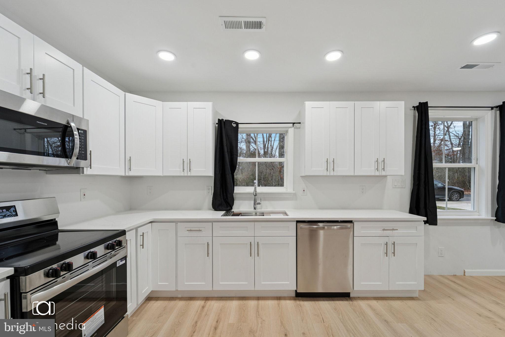 303 Gooseberry Road Millville, NJ 08332 - Photo 6 of 22 a kitchen with white cabinets stainless steel appliances and sink