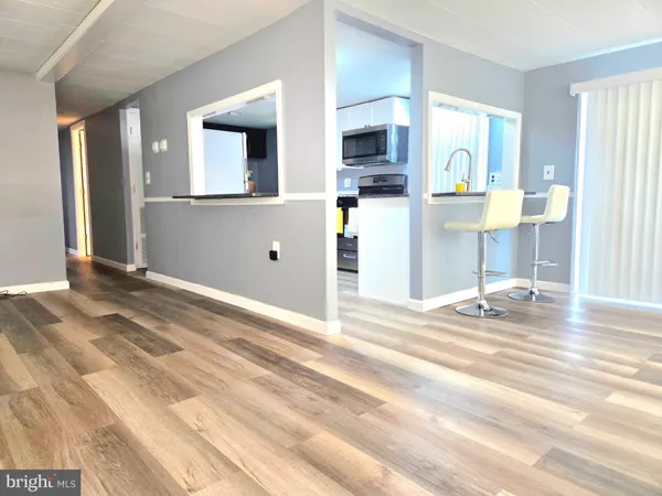 a view of a kitchen with kitchen island and stainless steel appliances