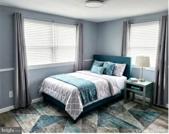 a bedroom with a bed table and two windows