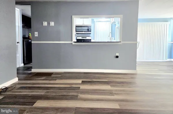 a view of a kitchen with wooden floor and a window