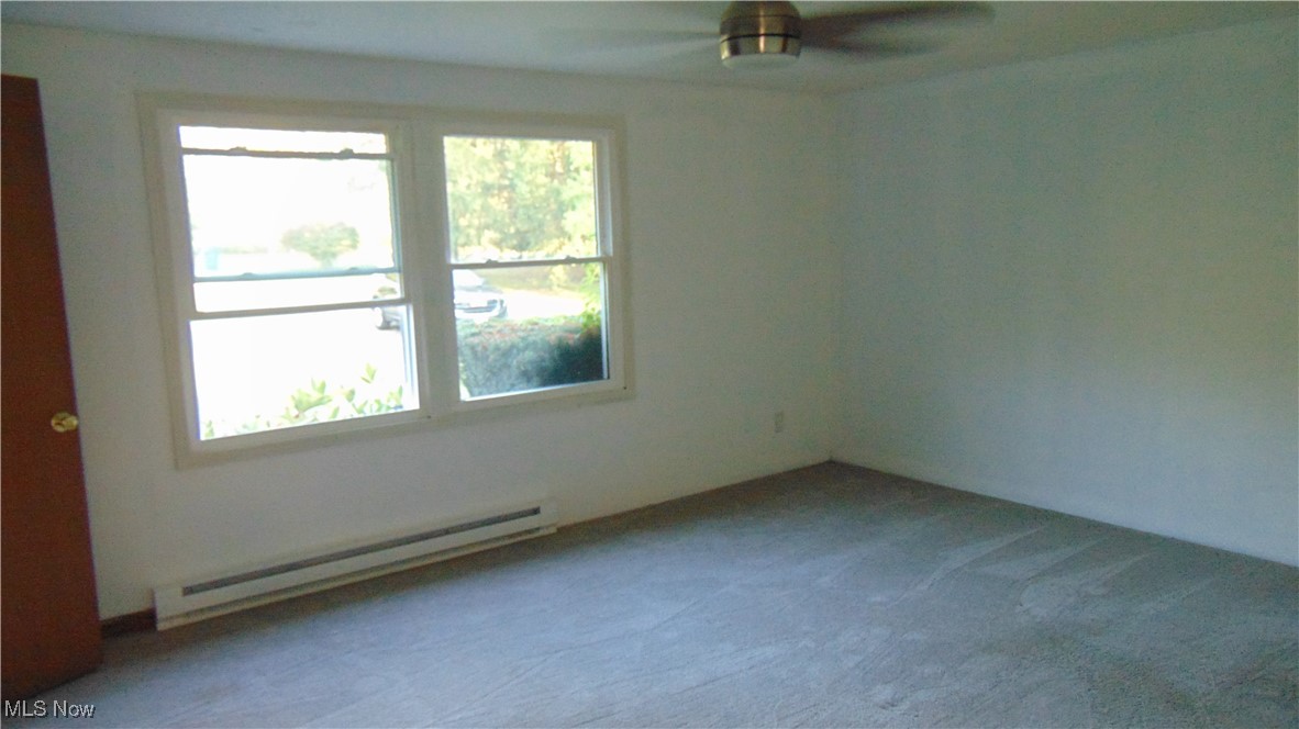 4970 Bryenton Road Litchfield, OH 44253 - Photo 18 of 33 Empty room with baseboard heating, carpet, and ceiling fan