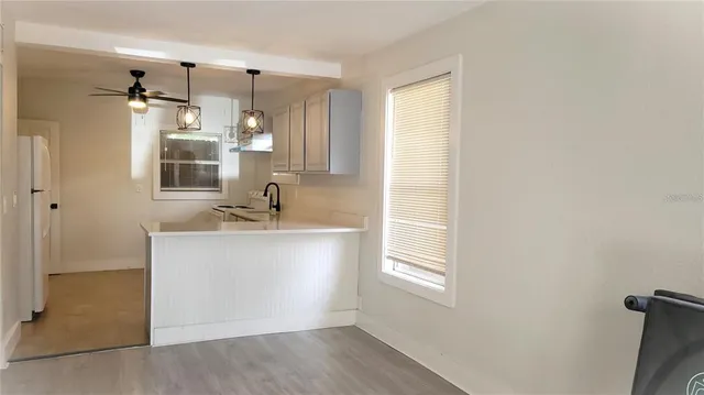 a kitchen with cabinets appliances and a chandelier