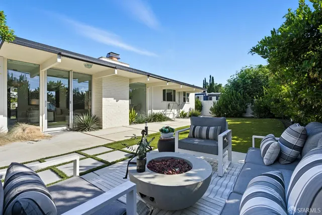 a view of a patio with couches table and chairs and potted plants
