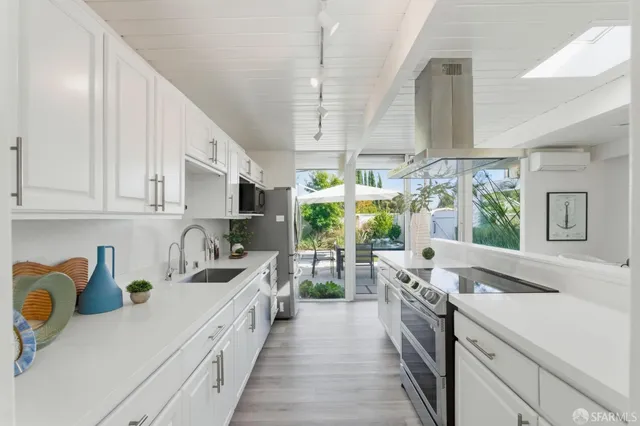 a kitchen with stainless steel appliances a refrigerator sink and wooden cabinets
