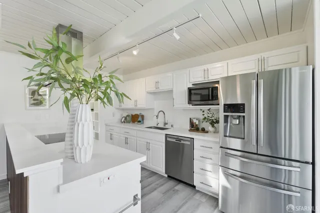 a kitchen with stainless steel appliances granite countertop a sink and a microwave