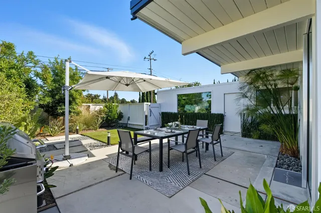 a view of a patio with a table and chairs under an umbrella