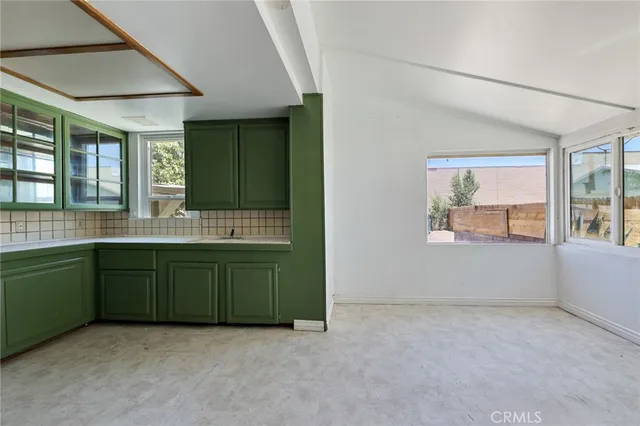 an empty room with window and cabinet