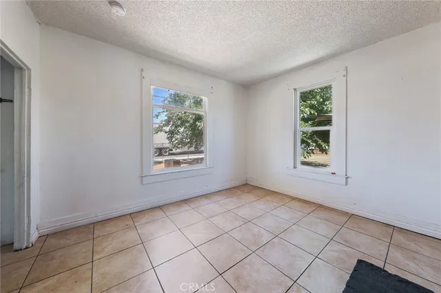 a view of an empty room with window and cabinet
