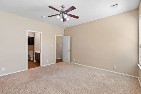 an empty room with a ceiling fan and a window