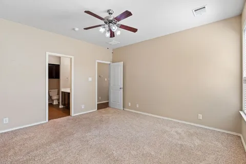 an empty room with a ceiling fan and a window
