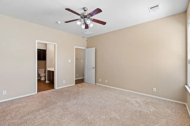 an empty room with a ceiling fan and a window