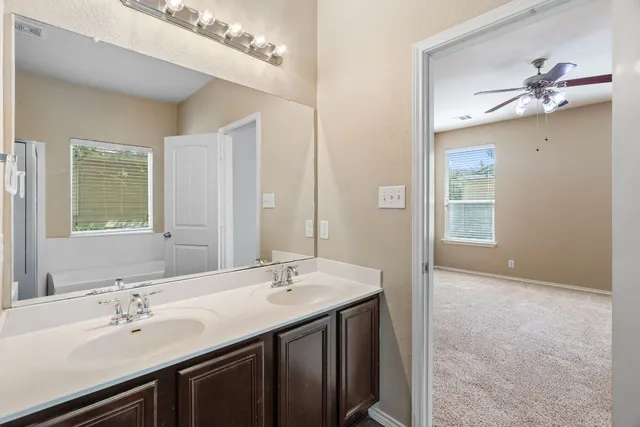 a bathroom with a double vanity sink a mirror and a shower