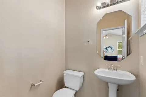 a bathroom with a toilet a sink and mirror