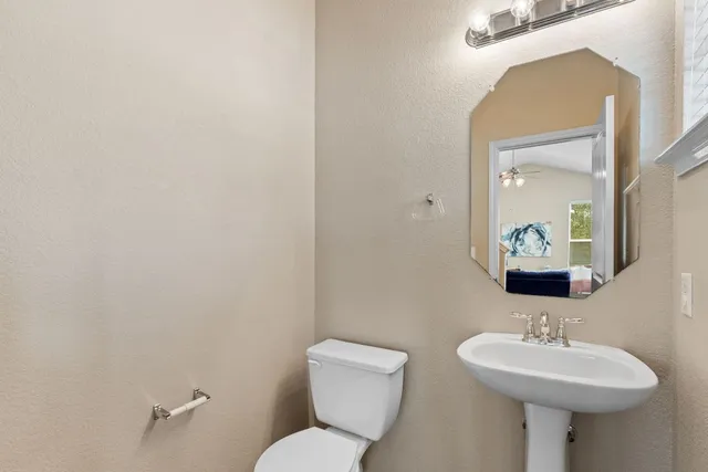 a bathroom with a toilet a sink and mirror
