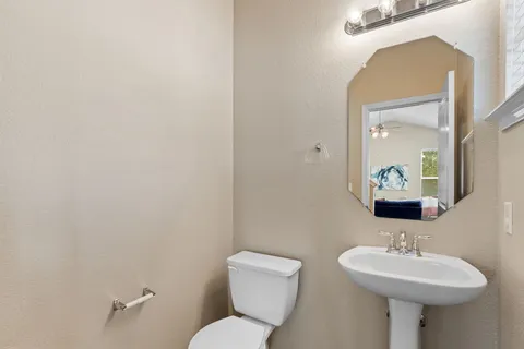 a bathroom with a toilet sink and mirror