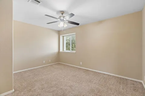 an empty room with windows and fan
