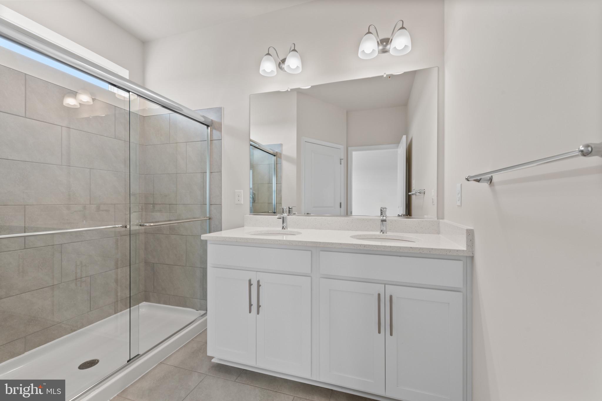 329 Ensemble Way Frederick, MD 21701 - Photo 31 of 40 a bathroom with a shower sink and mirror