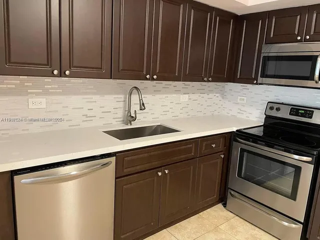 a kitchen with granite countertop a stove microwave and sink