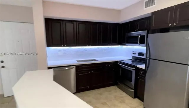 a kitchen with a sink cabinets and stainless steel appliances