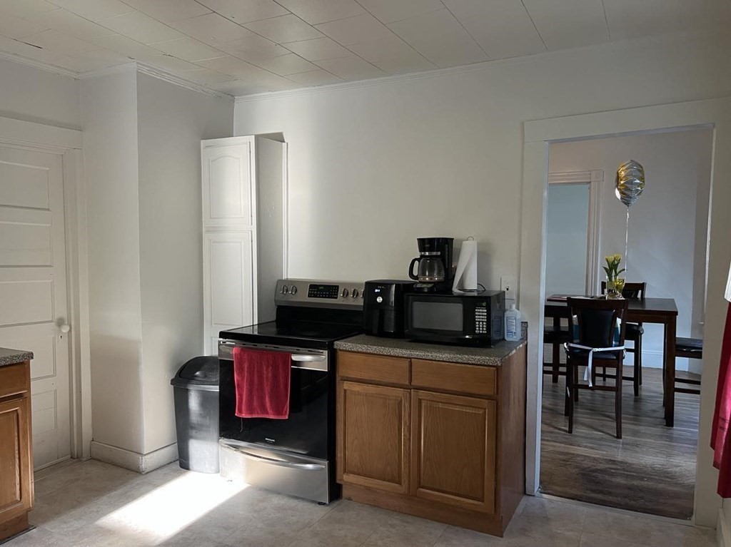 218 Oakland Street Springfield, MA 01108 - Photo 2 of 4 a room with furniture a flat screen tv and kitchen view