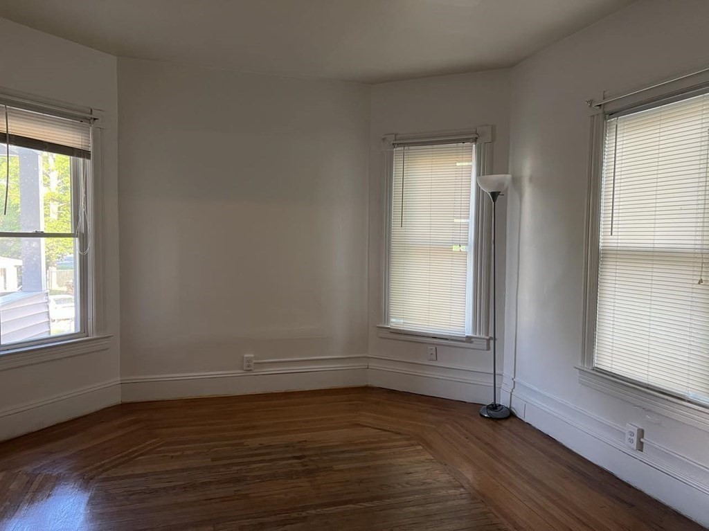 218 Oakland Street Springfield, MA 01108 - Photo 4 of 4 an empty room with wooden floor and windows