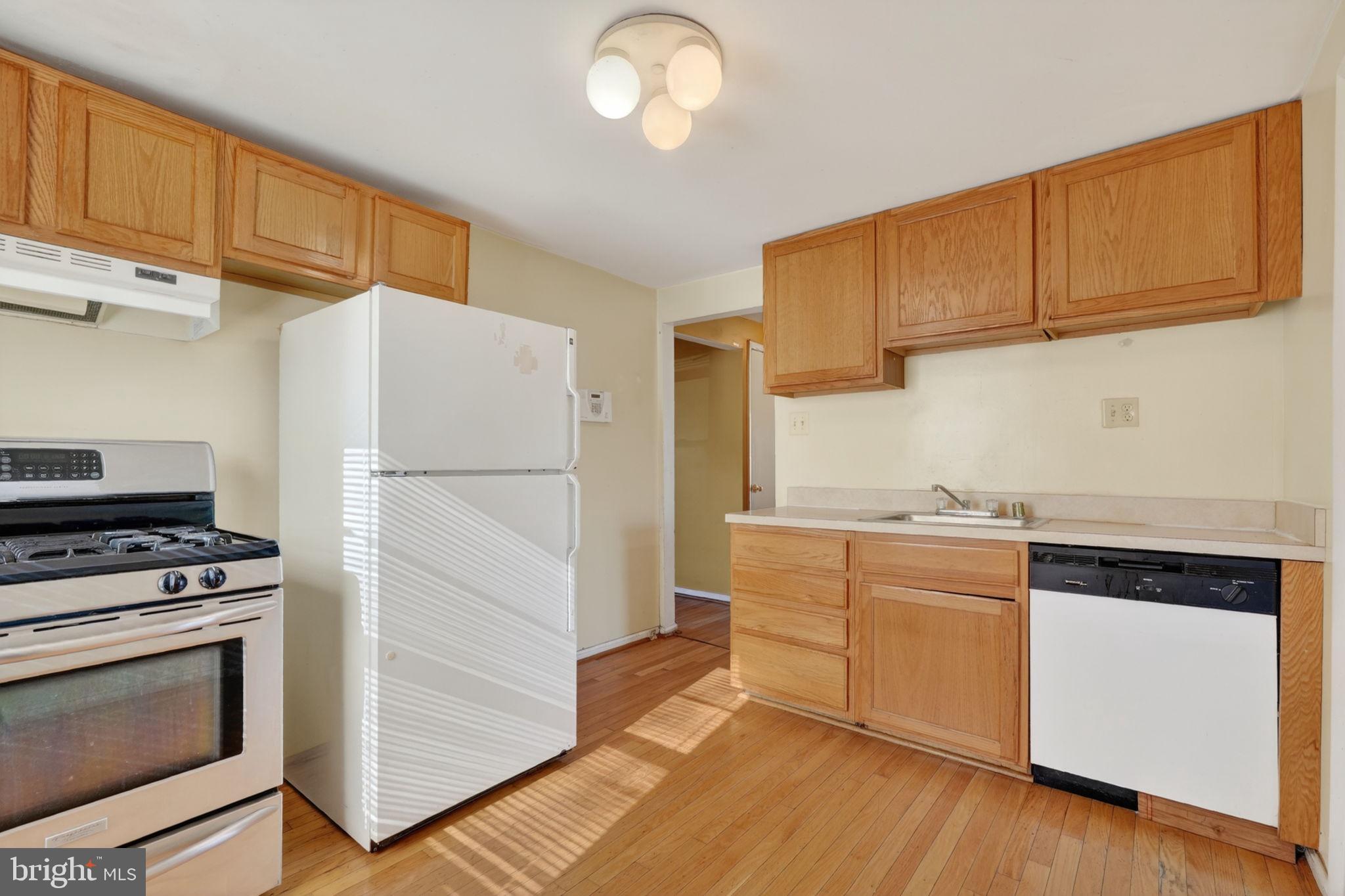 5441 Taussig Road Bladensburg, MD 20710 - Photo 10 of 37 a kitchen with cabinets appliances and a wooden floor