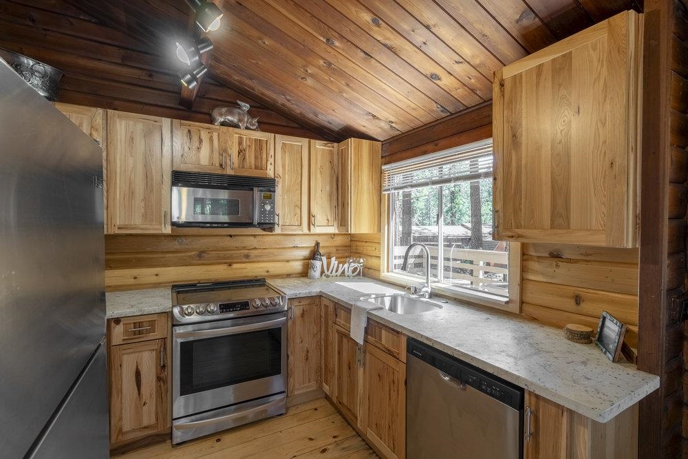 357 Wawasee Avenue Tahoe Vista, CA 96148 - Photo 13 of 28 a kitchen with stainless steel appliances sink stove microwave and cabinets