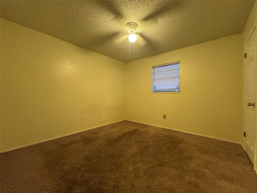 721 Mackey Ranch Road Bruceville-Eddy, TX 76524 - Photo 14 of 33 Carpeted room featuring a ceiling-mounted light fixture, a window with horizontal blinds, and a white interior door