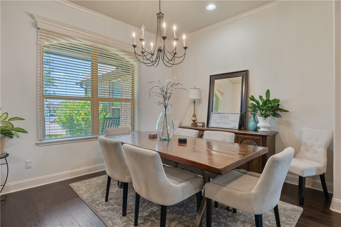 3301 Covington Court Bryan, TX 77808 - Photo 8 of 26 a view of a dining room with furniture a chandelier and wooden floor