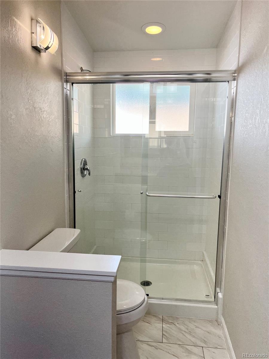 3907 Jasmine Street Colorado Springs, CO 80907 - Photo 14 of 23 a bathroom with a shower and a toilet