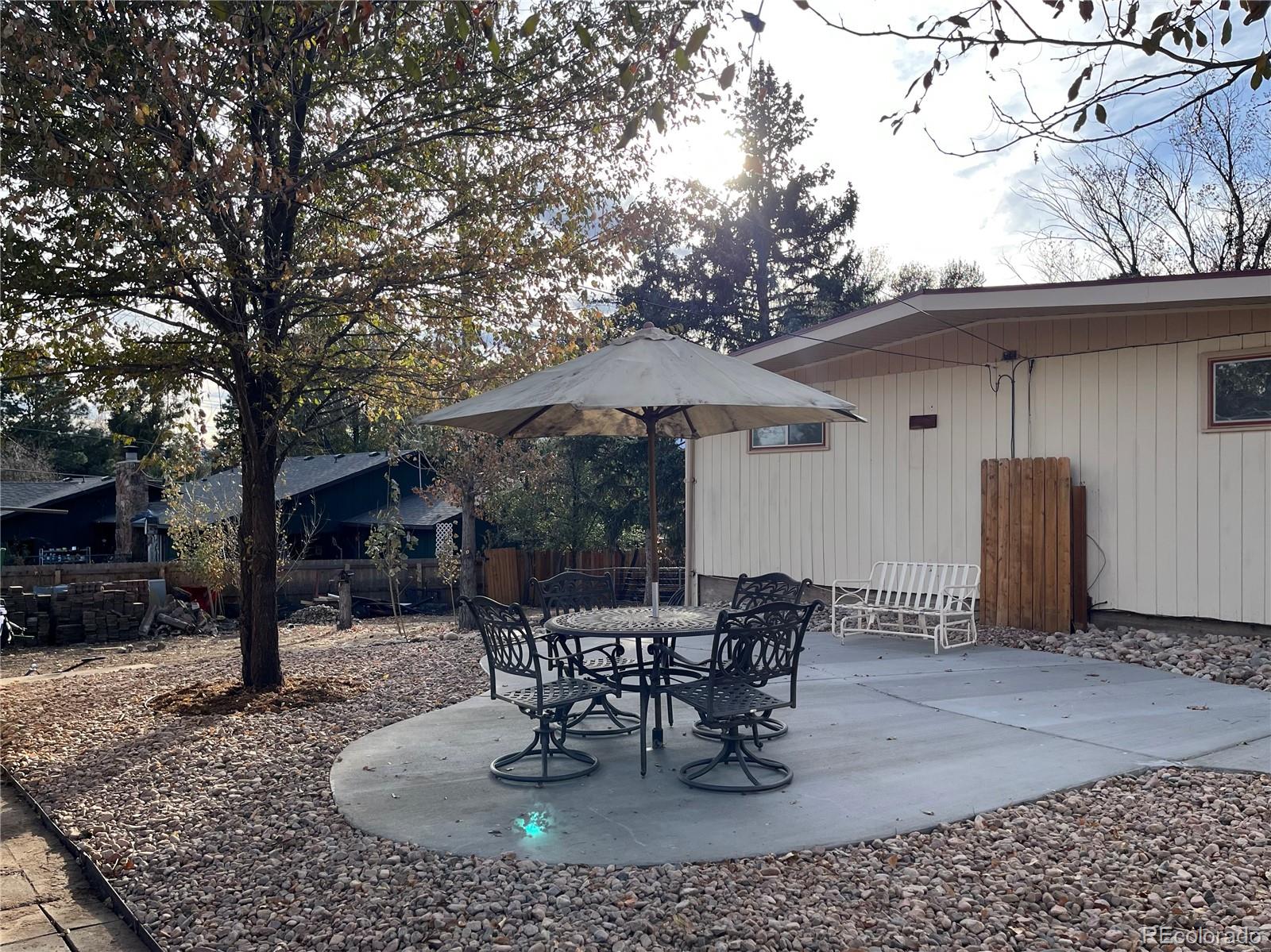 3907 Jasmine Street Colorado Springs, CO 80907 - Photo 19 of 23 a patio table and chairs with potted plants and a barbeque