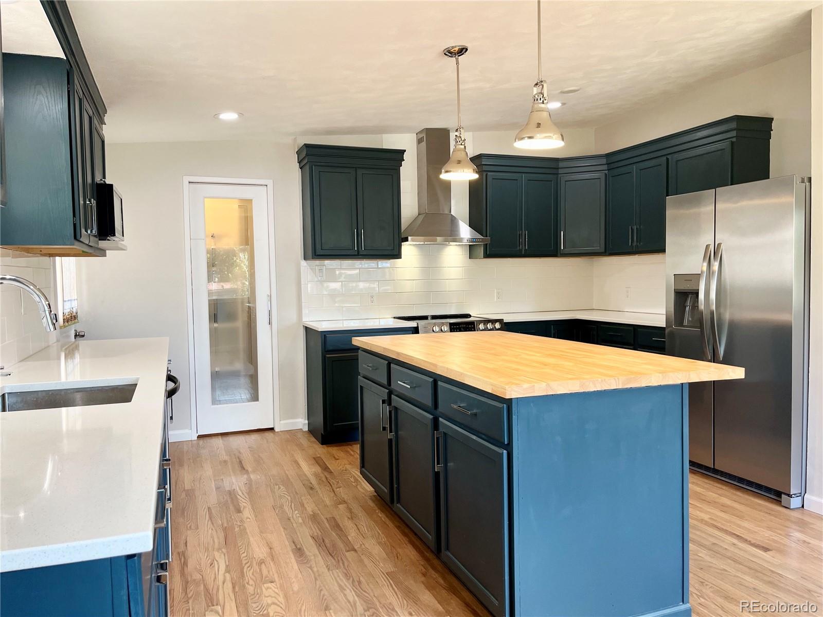 3907 Jasmine Street Colorado Springs, CO 80907 - Photo 7 of 23 a kitchen with stainless steel appliances kitchen island a large counter top space a sink and a stove