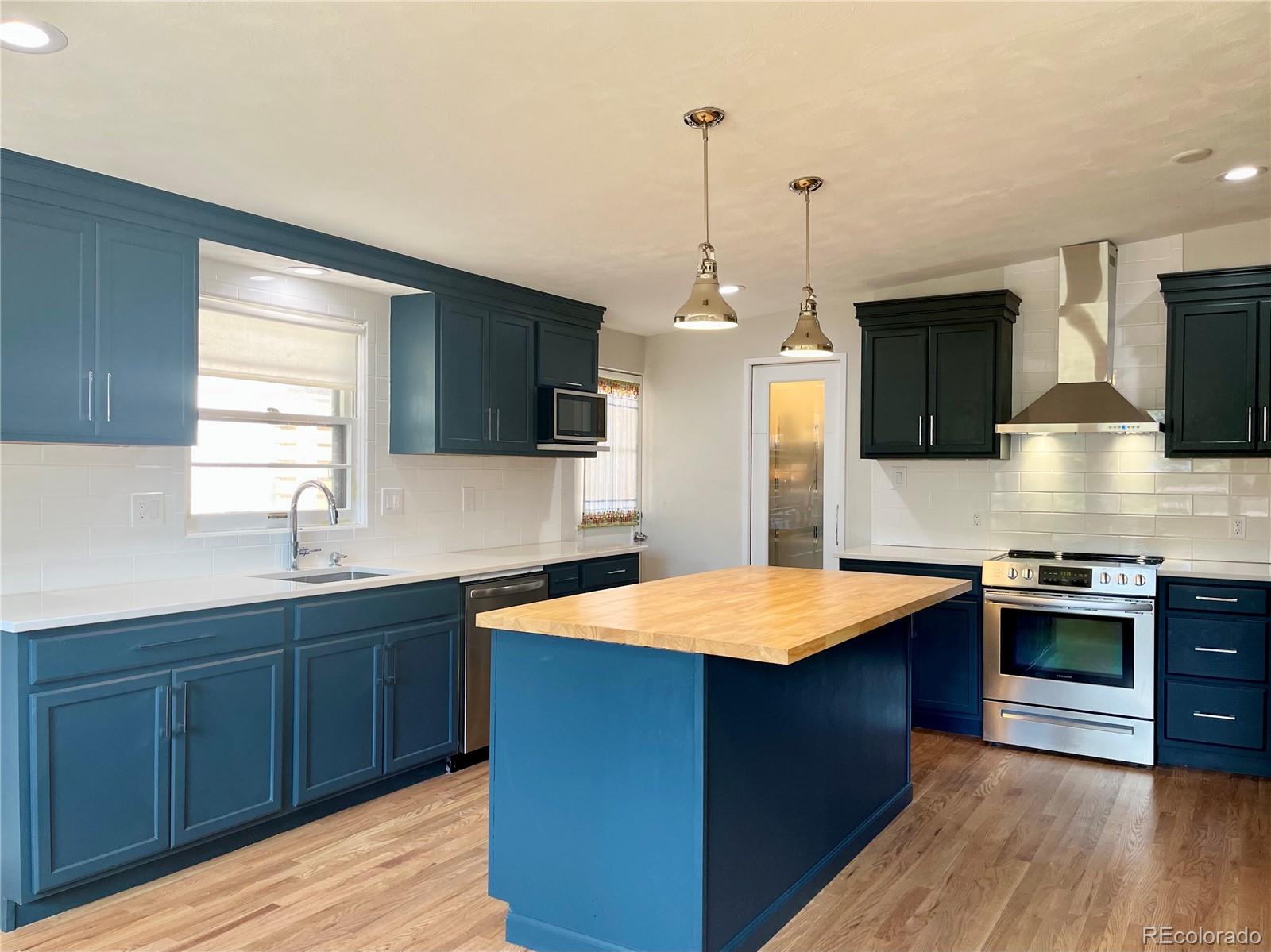 3907 Jasmine Street Colorado Springs, CO 80907 - Photo 9 of 23 a kitchen with stainless steel appliances granite countertop a sink stove and refrigerator