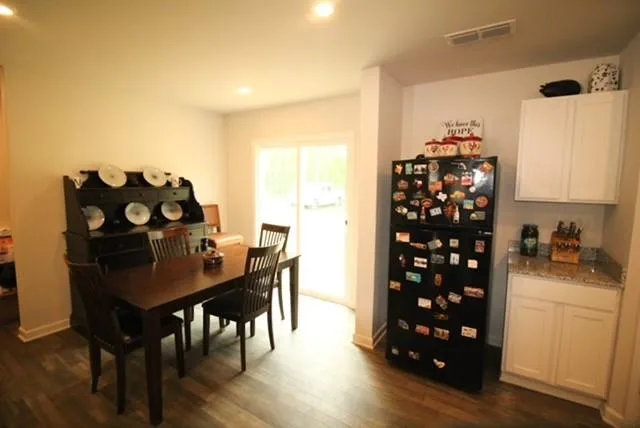 a kitchen with granite countertop a refrigerator stove and wooden floor
