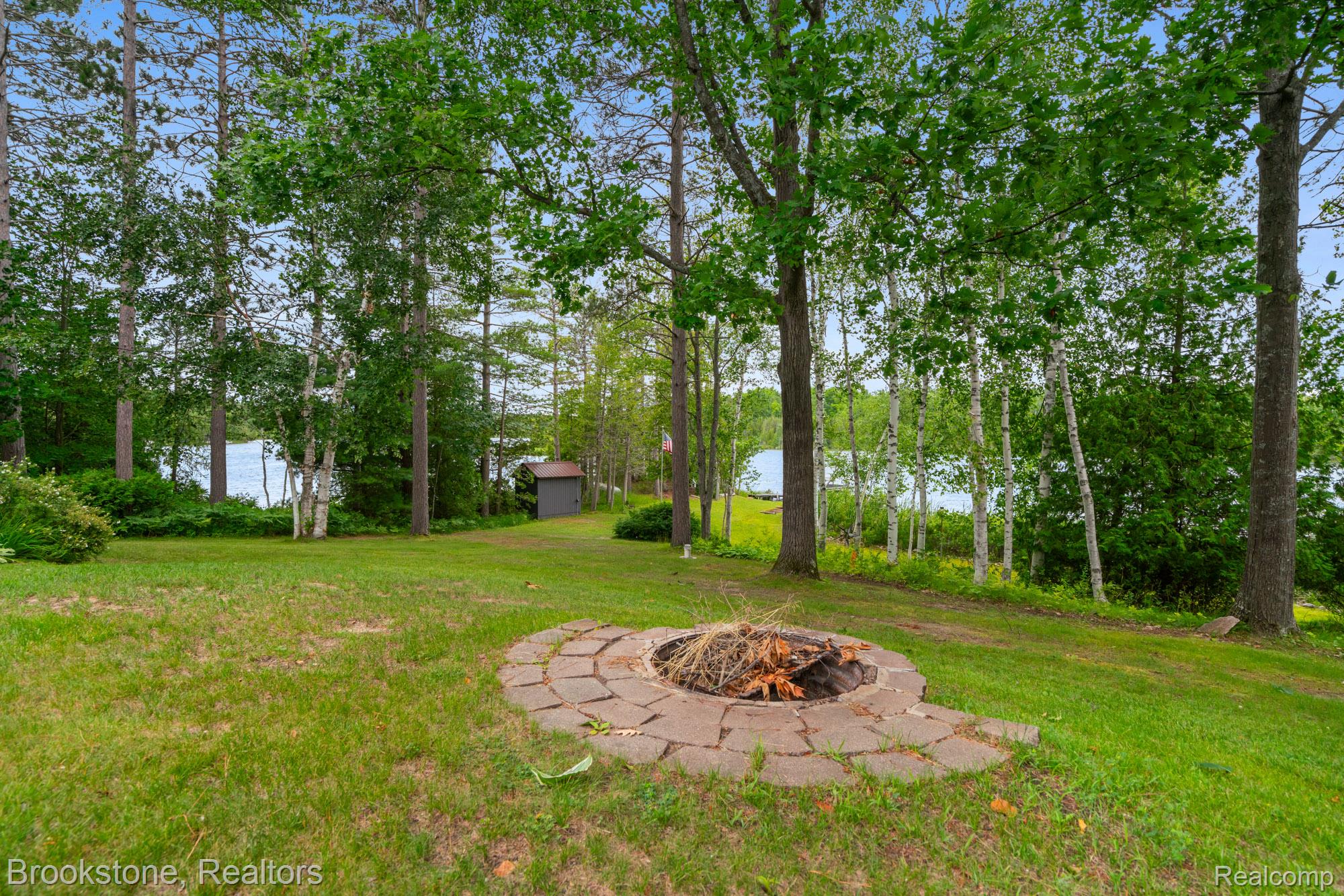 5699 Smith Road Cheboygan, MI 49721 - Photo 5 of 30 Expansive lawn area featuring a paver stone fire pit