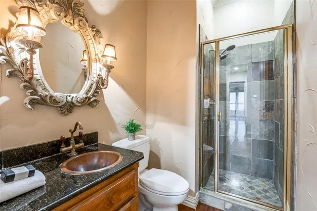 a bathroom with a granite countertop sink mirror and toilet