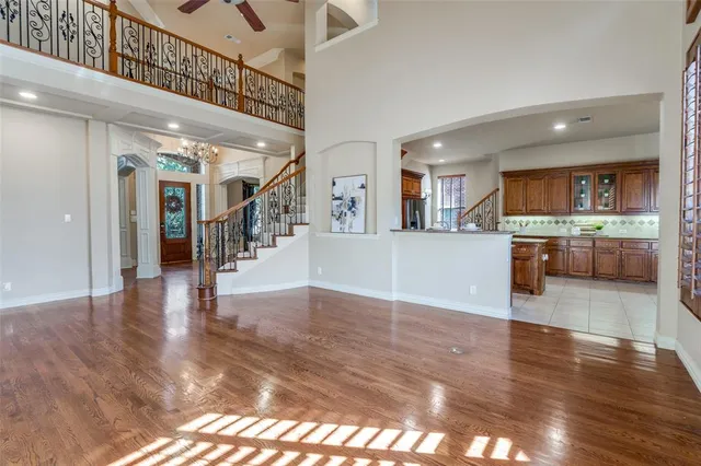 a view of a hallway with wooden floor and a kitchen