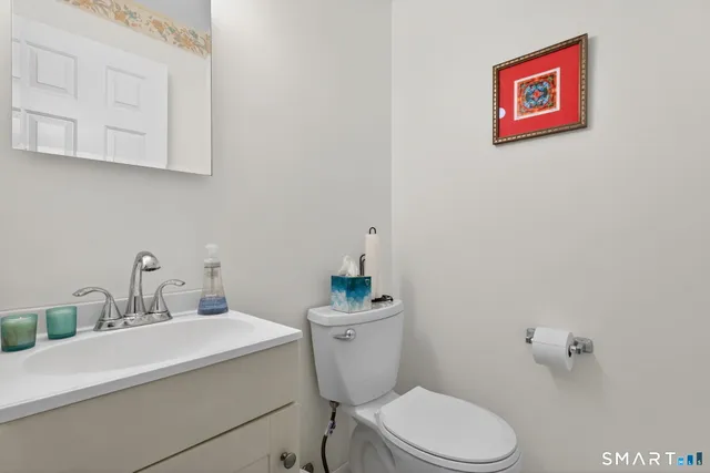 a bathroom with a sink mirror vanity and toilet