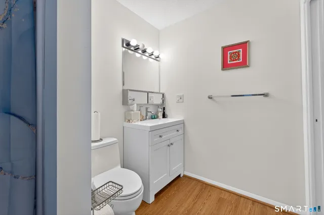 a bathroom with a toilet a sink and mirror